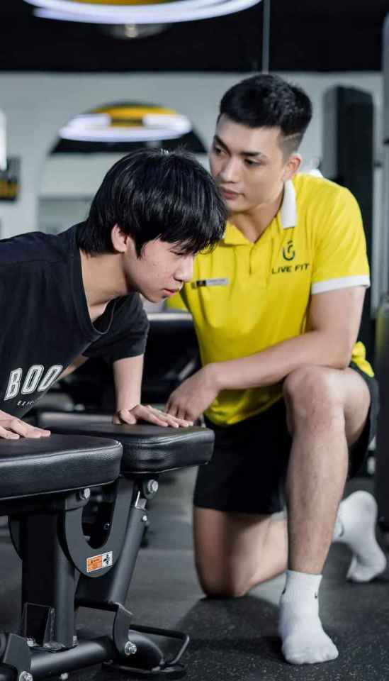 Huấn luyện viên đang chỉ bạn nhỏ tập